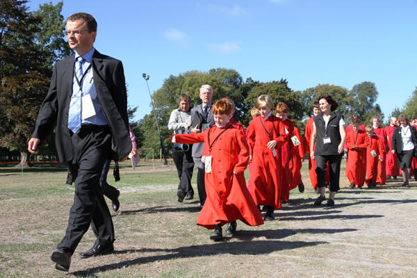 Chris Oldham, the ChristChurch Cathedral Administrator, leads the choir onto Hagley Park.