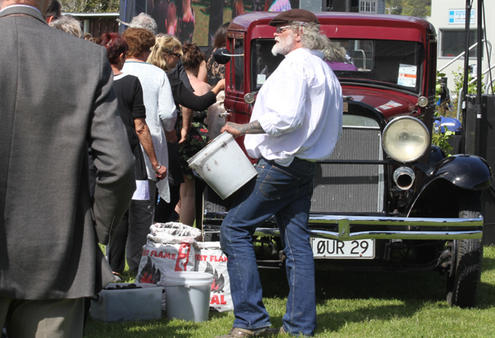 Mourners lined up to take a piece of coal and place it in the tray of the vintage Whippet truck - registration number: Our 29.