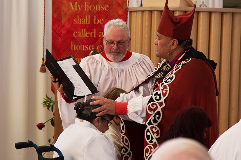 Bishop Kito anoints the Rev Irene Nelson. That's Michael Graveston supporting him.