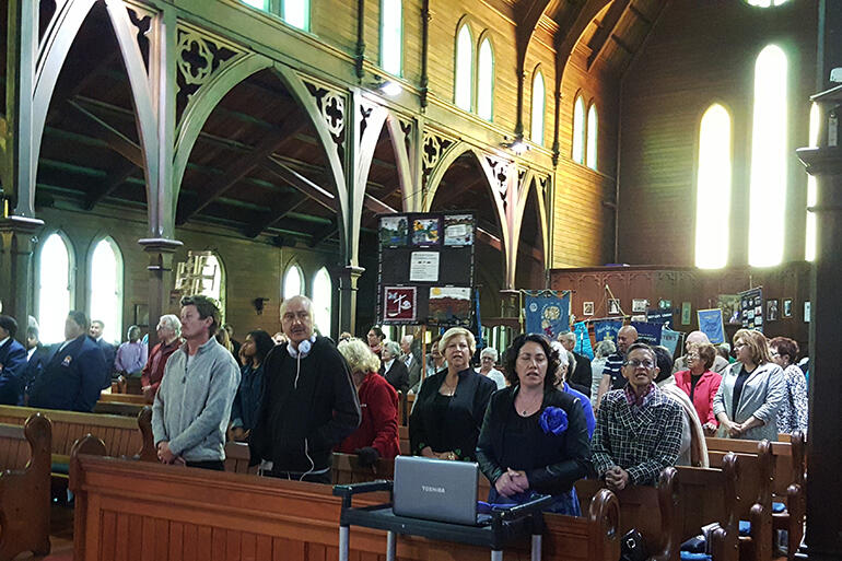 All stand as the ministry party processes into the church. Photo by Ukarau Kakepare.