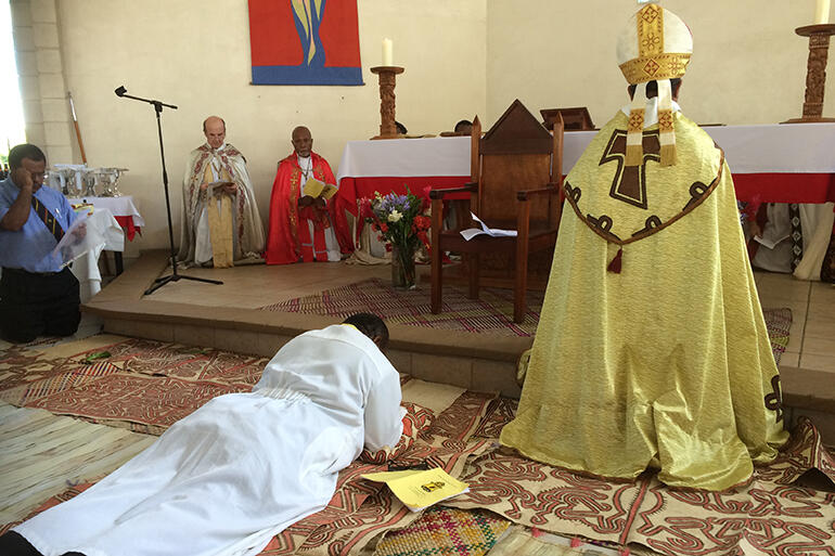 Bishop-to-be Denny Bray Guka prostrates himself before the altar at St Martin's Church, East Boroko.