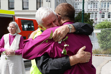 Karakia over, Dean Peter Beck embraces Bishop John Gray.