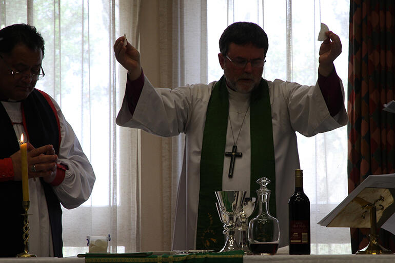 Silhouette of a sacrifice celebrated: Archbishop Philip Richardson presided at the Eucharist.