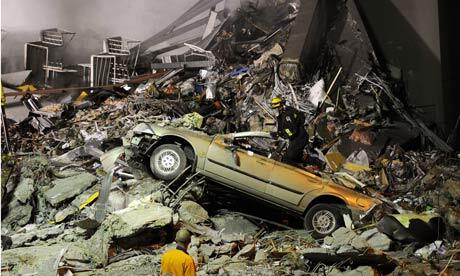 Rescue workers search for victims under the rubble near the Canterbury Television building. Photo: Shuzo Shikano/AP