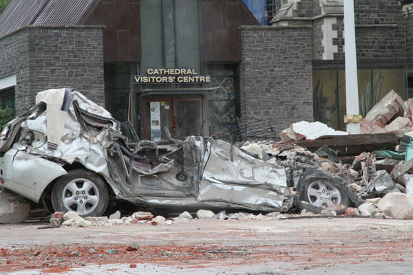 A car is flattened by rock from the cathedral spire. Photo: Lloyd Ashton