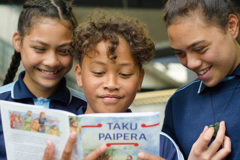 Three students read the Bible Society's new Māori language illustrated children's Bible at Middle School West Auckland’s Bilingual Unit.