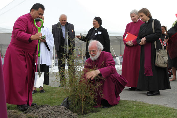 Archbishop Rowan plants a kowhai on the site where Waipounamu will erect a new church and community centre.