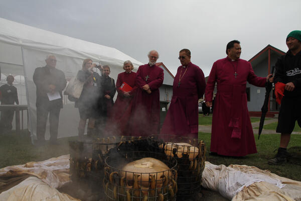 Archbishop Rowan watches as the hangi cooked for the occasion is lifted.