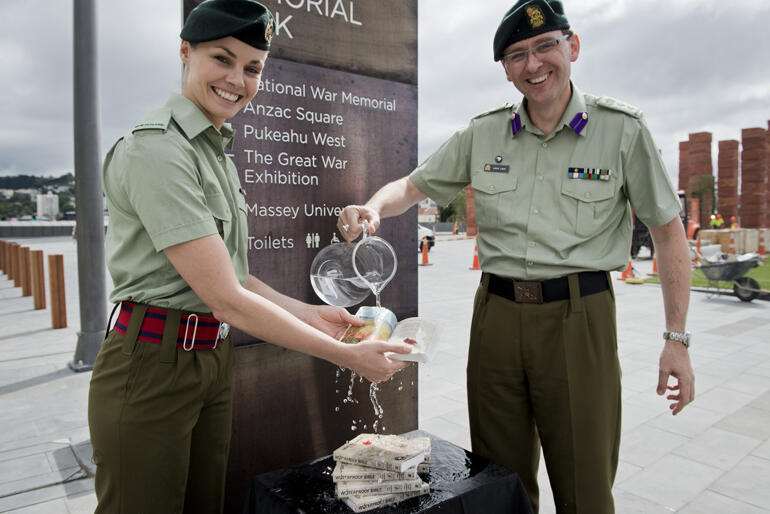 Second Lieutenant Claire Debrois and NZDF Chaplain Lance Lukin test the waterproof New Testaments at Pukeahu National War Memorial Park, Wellington.