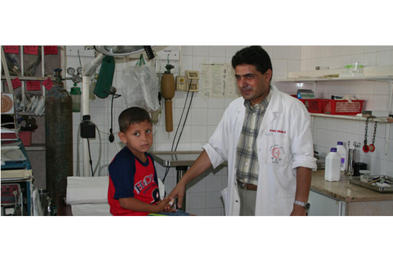 A doctor at Al Ahli Hospital treats a young Gazan resident.