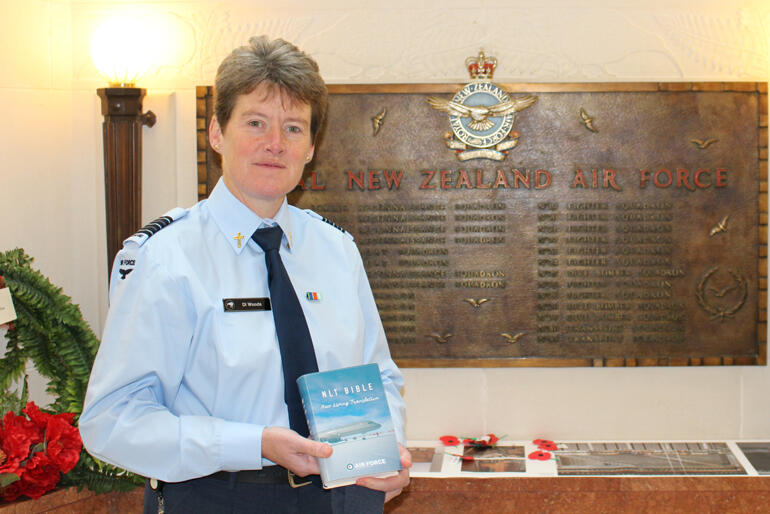 New Zealand Defence Force Chaplain Di Woods holds a copy of the new Air Force bespoke Bible.