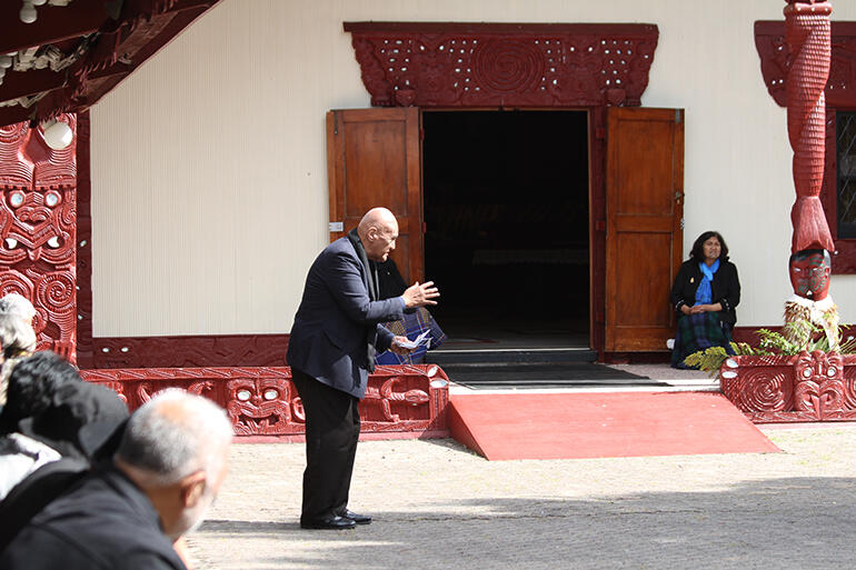 Koro Tawhiri acknowledges the koha given at the powhiri. He stands before the open door of Mahinarangi.