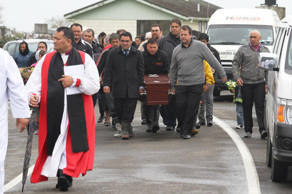 Bishop Kito Pikaahu leads the pallbearers out of the marae across the road to the urupa.