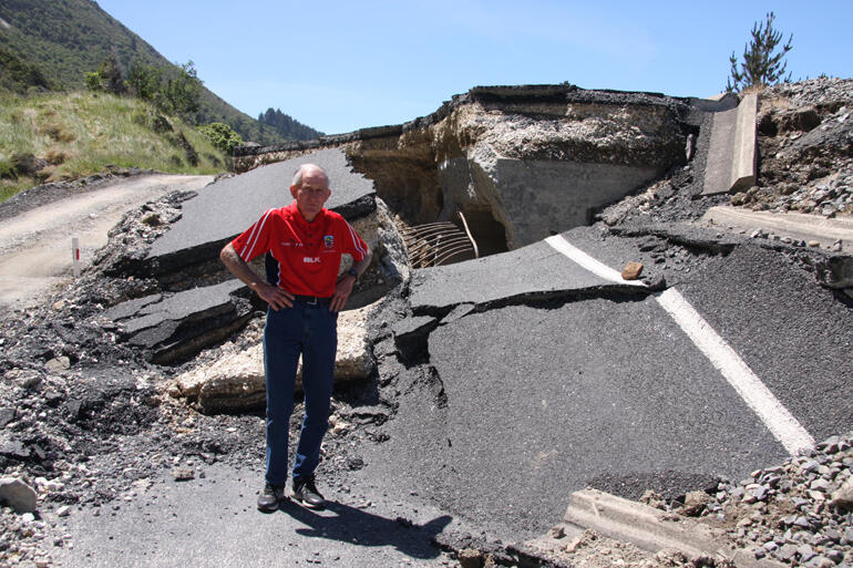 Malcolm Taylor stands on a formerly flat section of road, which was thrust up by over a metre in the Nov 14 earthquake. 