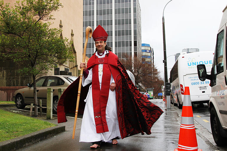 File shot: The cathedral is on Bishop Justin Duckworth's right - and the stricken office block is immediately behind him.