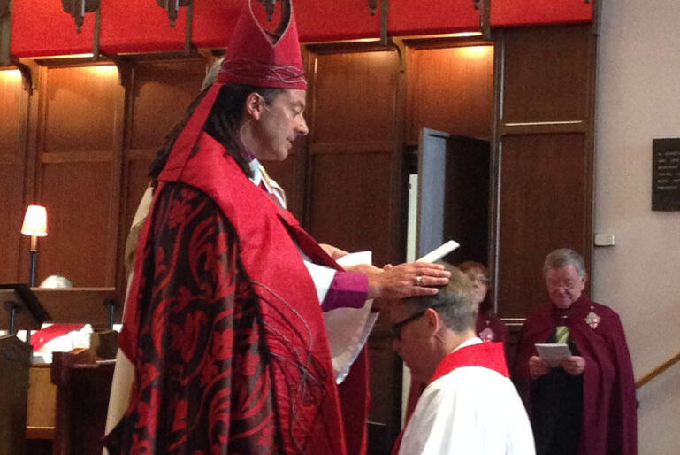 Bishop Justin Duckworth prays over Wellington's new Dean.