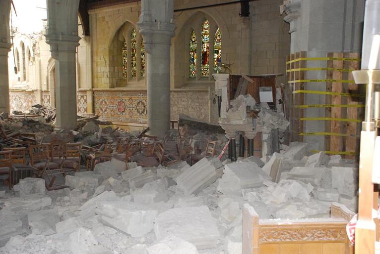 Rubble fills the nave of ChristChurch Cathedral. The pulpit has been partially destroyed.