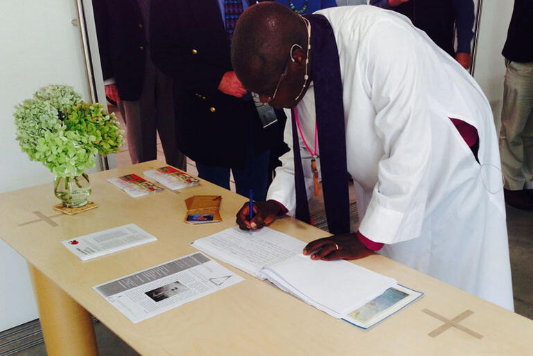 Dr Sentamu signs the Transitional Cathedral visitors' book.