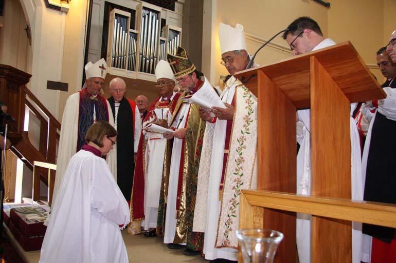 Bishop-elect Helen-Ann kneels at the invocation.