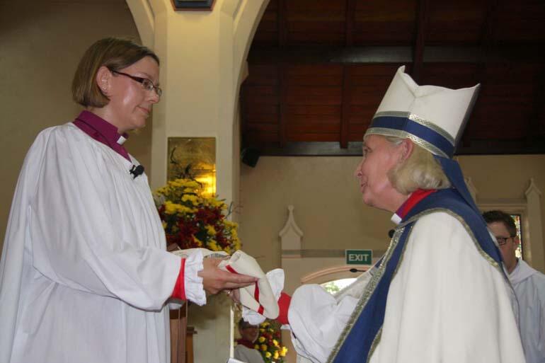 On behalf of the gathered bishops, Bishop Victoria Matthews presents Bishop Helen-Ann with her chole.