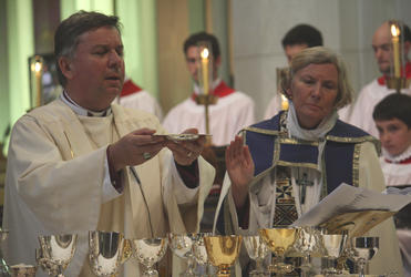 Archbishop David Moxon celebrates as Bishop Victoria looks on.