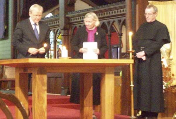Kevin Rudd lights a candle for victims of the Christchurch quake. Looking on are Bishop Victoria and Father Peter Williams.