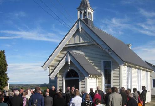 The congregation gathers at the front of Morven Church at the end of its closing service on May 20.