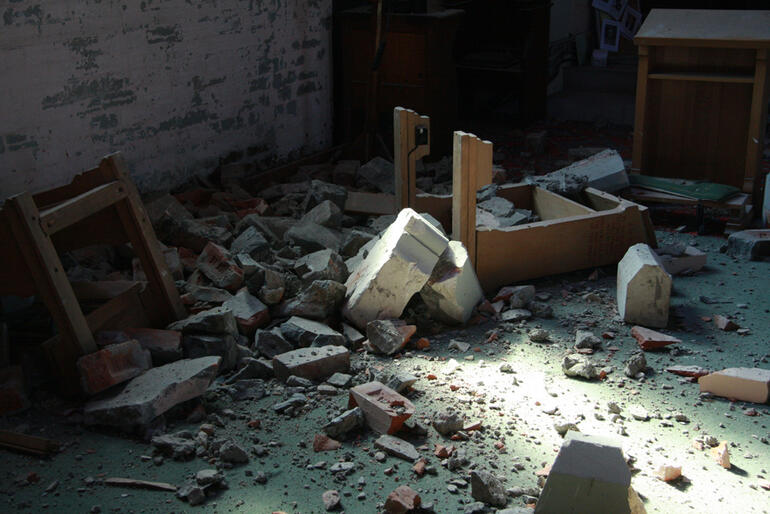 Rubble and upended prayer kneelers near the organ loft at Holy Trinity Avonside.