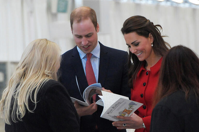 Author Clare Erasmus (left) presents a copy of her children's book: ‘Kia Kaha’s Brand New House” to the royal couple for baby George. 