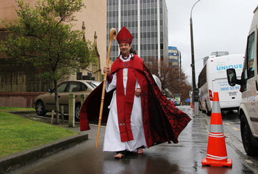 The new barefoot bishop walks down Molesworth St towards the Canterbury Door of the cathedral.