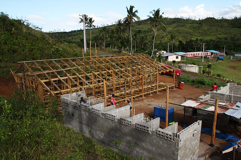 A view over the new dormitory towards Tokaimalo District School. The cyclone tore the roof off the pink classroom block.