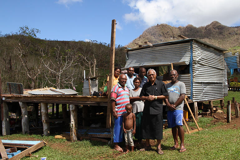 Flashback to February: Mosese Kakaramu and Archbishop Winston stand in front of the remains of Mosese's house.