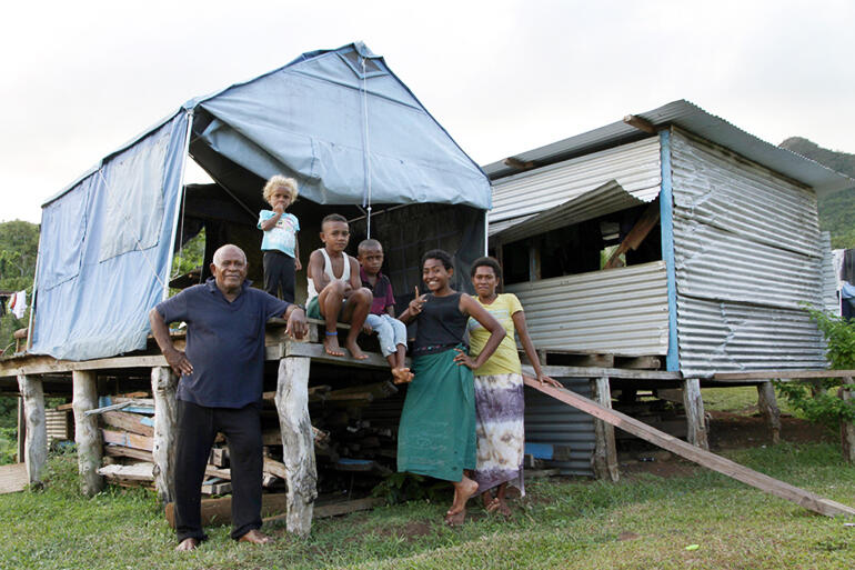 That's Mosese Kakaramu at left, with his family, and the tent they live in these days. Mosese was the village chief.