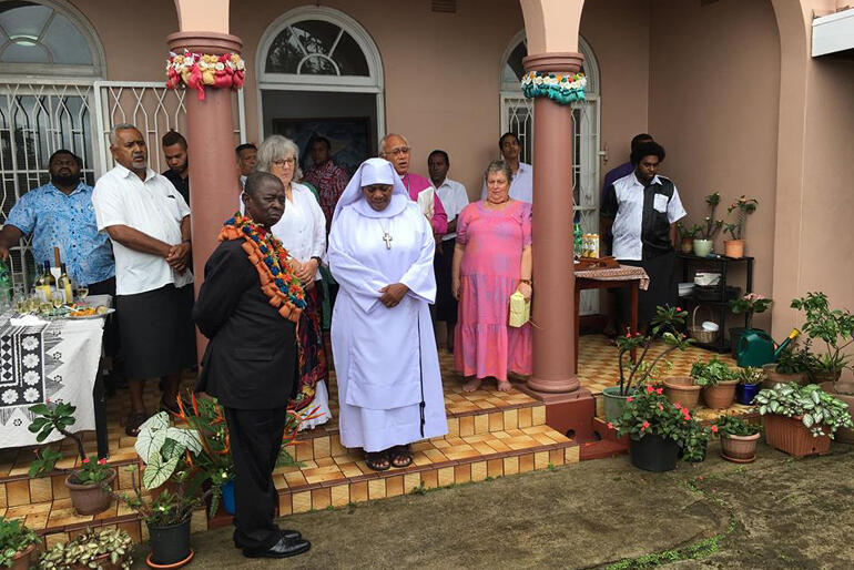 Diocese of Polynesia hosts gather for prayer on the steps of Archbishop Winston's home as they welcome delegates to a Sunday feast.