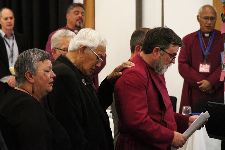 The Archdeacon extends his hand to Archbishop Philip during his solemn reading of the church's apology to Tauranga Iwi at the 2018 General Synod.