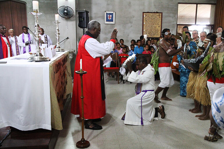 Archbishop George Takeli of Melanesia blesses the Bible, which is about to be read by Fr Harry Gereniu.