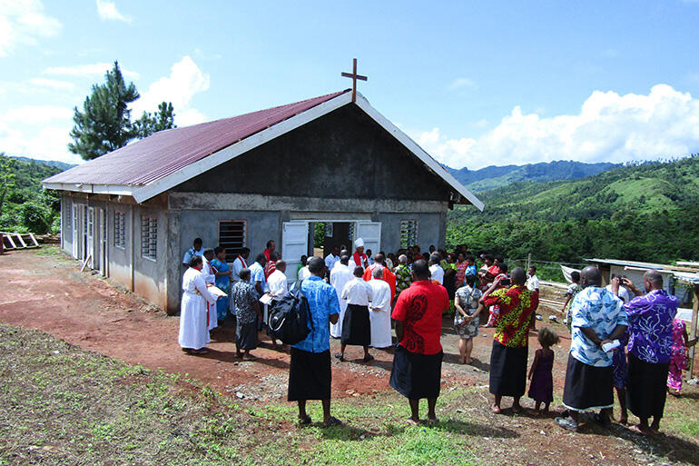 Archbishop Winston speaks to the villagers before they file into the church for the first service.