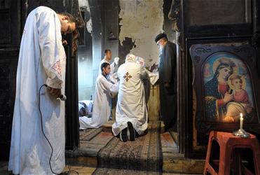 Egyptian Coptic Christian priests say prayers for those killed in clashes between Muslims and Christians. Photo: EPA