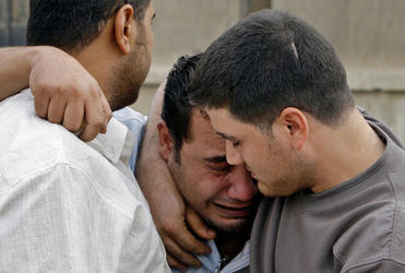 A grieving Iraqi is consoled by friends after the Baghdad hostage killings.