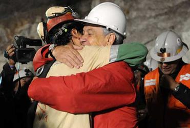 First out of the mine: Chilean miner Florencio Avalos is embraced by President Sebastian Pinera.