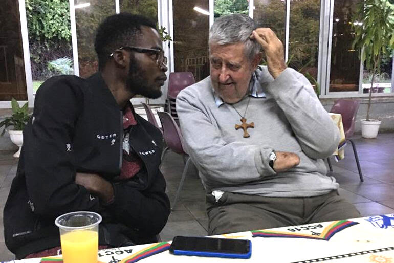 Rwandan student Christian Miko talks with Bishop John Osmers at St Luke's Cathedral, Msoro, Christmas 2020.
