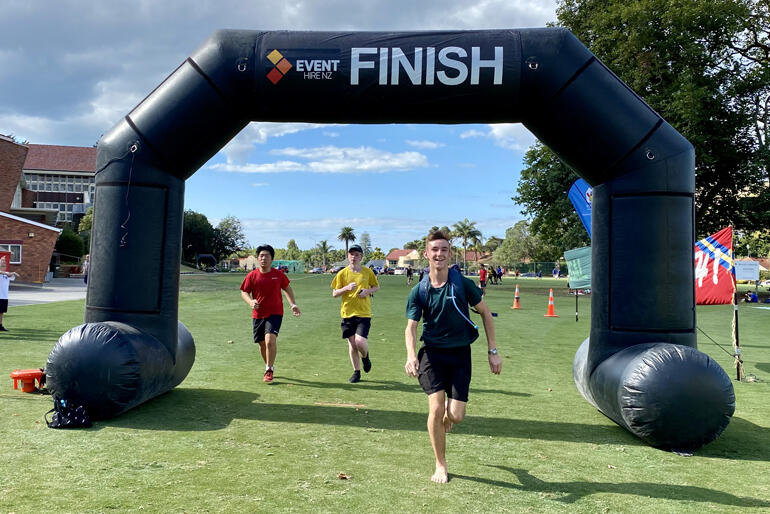 Dilworth Anglican School students cross the finish line during their run for the House to House fundraising event.