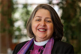 Archbishop Marinez Bassotto smiles at the camera in her purple clericals