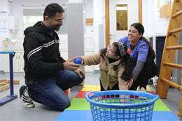 A Palestinian child receives rehabilitation from two medical professionals at Princess Basma Centre in East Jerusalem