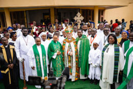 +Sarah Mullally stands in cope and mitre amidst female clergy and the whole crowd of worshippers outside a church in Accra.