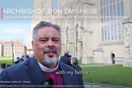 Archbishop Don Tamihere stands with the sunlit Canterbury Cathedral in the background