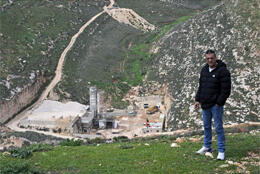 A Palestinian Christian stands on the hill above his brother limestone quarry