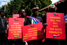 African activists hold placards opposing Uganda's death sentencing anti-gay laws