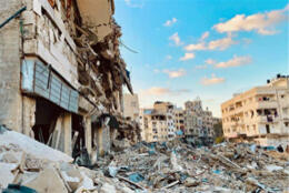 A bombed neighbourhood shows rubbles under the Middle Eastern sun