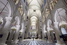 Gothic pillars and arches in grey tones with checked floors inside Notre Dame Cathedral